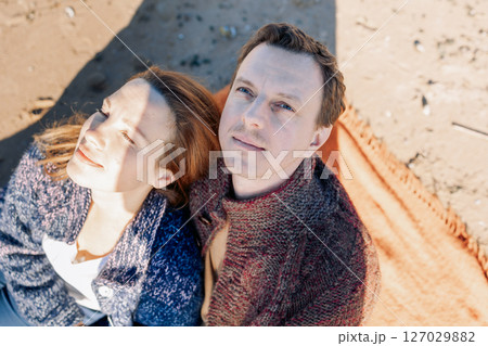 Portrait loving couple walks on beach along sea on sunny autumn day. Weekend and lifestyle concept. High quality photo 127029882