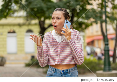 Angry mad stressed woman arguing while talking on smartphone conversation irritated shout quarrel 127030365