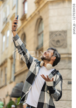 Young male tourist trying to catch communication signal and Internet on smartphone in city street Young male tourist trying to catch communication signal and Internet on smartphone in city street 127030438