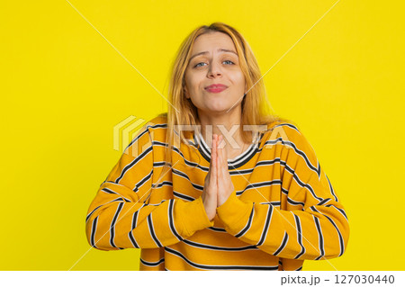 Young woman praying making wish, asking hopeful help, begging apology, meditation, imploring Young woman praying making wish, asking hopeful help, begging apology, meditation, imploring 127030440