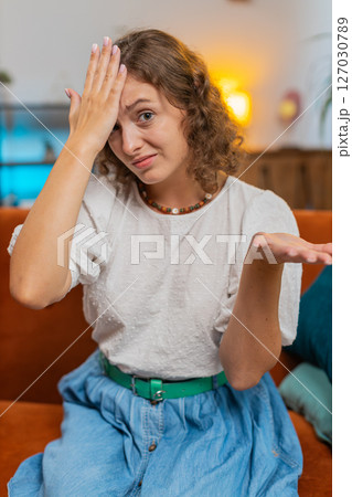 Upset woman making disrespect gesture, disappointed in fail results bad news on sofa couch at home 127030789