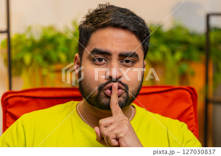 Indian man presses finger to lips makes silence hush sign do not tells gossip secret, quiet 127030837