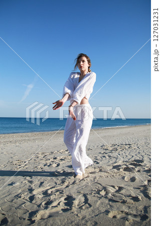 Italian Girl Dances On The Soft Beach Near Ocean In White Clothes 127031231