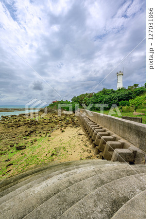 梅雨空の下に佇む琉球観音埼灯台と静かな海岸線　干潮の岩場が広がる石垣島の海岸 127031866