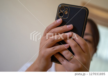 スマホを操作する主婦の手 127031895