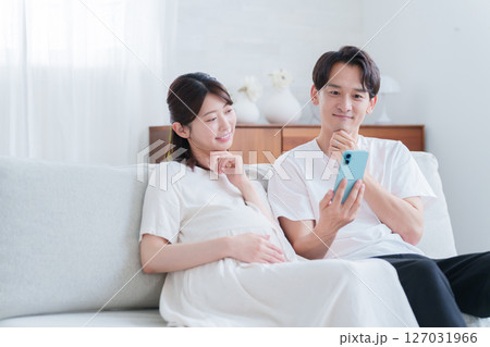 スマホを見る妊婦の妻と夫 127031966