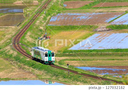 春の農作業を横目に曲線の線路に沿って走る由利高原鉄道 127032182