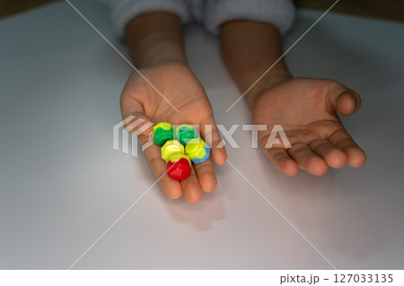 Korean traditional game kit Gonggi. Colourful plastic stones on the hand. Korean traditional game kit Gonggi. Colourful plastic stones on the hand. 127033135