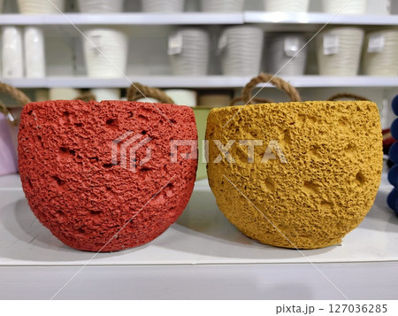 colorful textured pots in vibrant red and yellow displayed on shelf in home decor store. closeup. 127036285