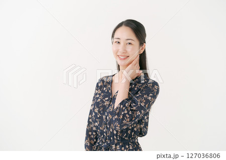 白い背景の前で笑顔の若い女性 127036806