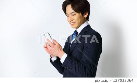笑顔でスマホを操作する男性会社員イメージ 笑顔でスマホを操作する男性会社員イメージ 127038364