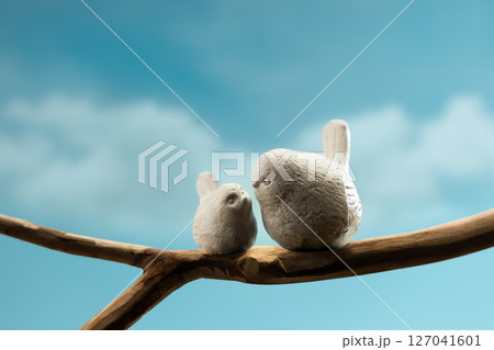 Mother and baby birds perched on branch, symbolizing family love, motherhood, care, and emotional bonding in nature Mother and baby birds perched on branch, symbolizing family love, motherhood, care, and emotional bonding in nature 127041601