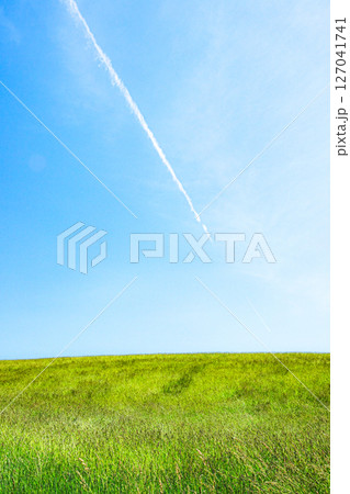飛行機雲と風を感じる爽やかな夏の北海道のイメージ風景 飛行機雲と風を感じる爽やかな夏の北海道のイメージ風景 127041741