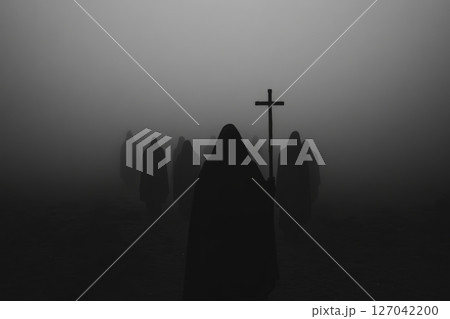 Figures in cloaks walking through thick fog carrying a cross during a mysterious dark setting Figures in cloaks walking through thick fog carrying a cross during a mysterious dark setting 127042200