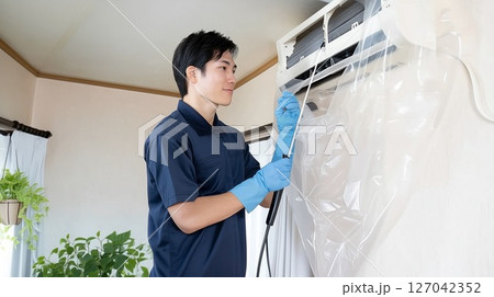 男性清掃スタッフによるエアコン清掃の様子。夏のエアコンクリーニング 127042352