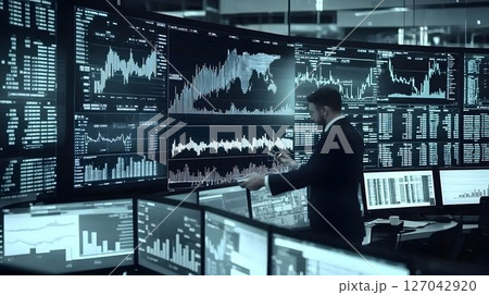 Businessman analyzing data on multiple screens in a modern office 127042920