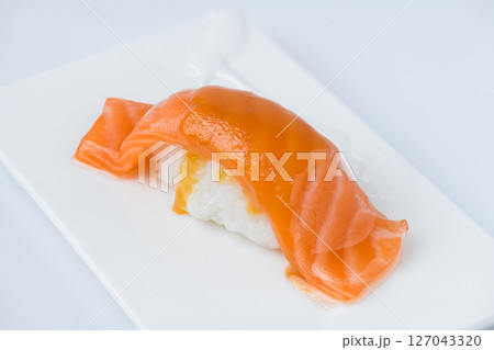 Fresh Salmon Nigiri Sushi Drizzled with Savory Sauce on Minimalist Plate 127043320