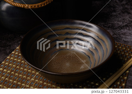 Empty Japanese Ceramic Bowl and Teapot Set on Bamboo Mat 127043331