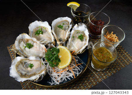 Fresh Oysters Platter with Assorted Condiments and Lemon 127043343