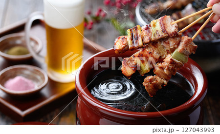 炭火焼き鳥をタレにくぐらせる臨場感ある料理写真 炭火焼き鳥をタレにくぐらせる臨場感ある料理写真 127043993