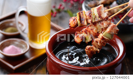 焼き鳥を秘伝のタレ壺にくぐらせるシズル感ある和風カット 127044001