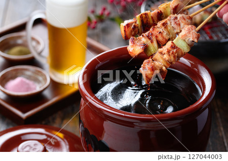焼き鳥を秘伝のタレ壺にくぐらせるシズル感ある和風カット 127044003