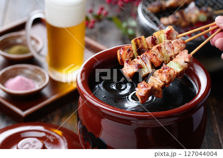 焼き鳥を秘伝のタレ壺にくぐらせるシズル感ある和風カット 焼き鳥を秘伝のタレ壺にくぐらせるシズル感ある和風カット 127044004