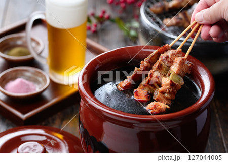 焼き鳥を秘伝のタレ壺にくぐらせるシズル感ある和風カット 127044005
