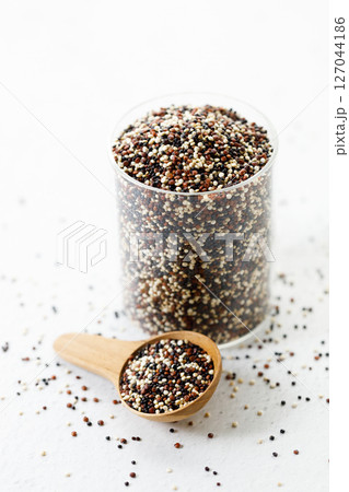 Mix of white, black and red quinoa seeds in wooden spoon. Mix of white, black and red quinoa seeds in wooden spoon. 127044186