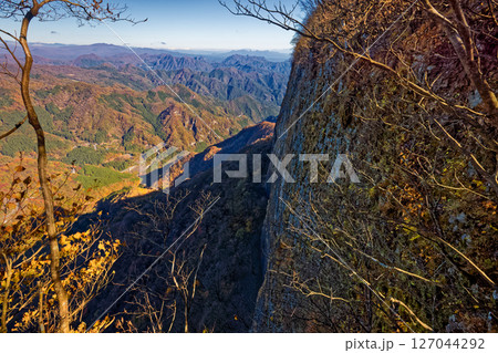西上州・艫岩の岩壁と紅葉の妙義山方面の山並み 127044292