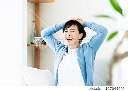 リビングでリラックスして過ごす中高年女性 リビングでリラックスして過ごす中高年女性 127044693
