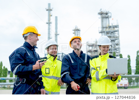 Four petrochemical workers or technicians work together with one hold laptop and they stand in front the factory. Four petrochemical workers or technicians work together with one hold laptop and they stand in front the factory. 127044816