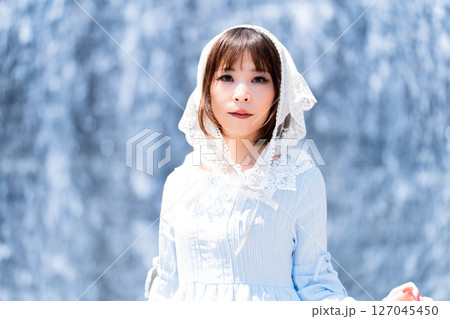 滝の前に立つクラシカルロリータファッションの女性 127045450
