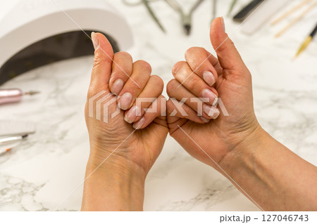 Nail manicure at home, female hands showing her nails. Nail manicure at home, female hands showing her nails. 127046743