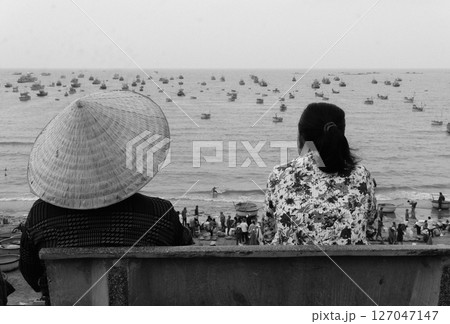 woman in hat sitting on the edge of the sea 127047147