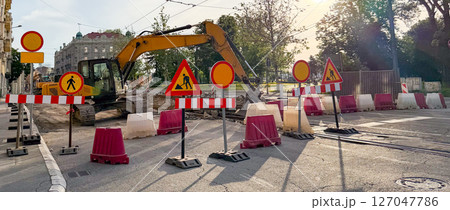 Banner urban construction site with excavator and warning signs during street repairs. Urban infrastructure and public works Banner urban construction site with excavator and warning signs during street repairs. Urban infrastructure and public works 127047786