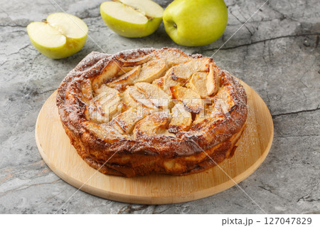 Apple Clafoutis is a delightful French-inspired dessert that combines tender, caramelized apples with a rich custard-like batter close-up. horizontal Apple Clafoutis is a delightful French-inspired dessert that combines tender, caramelized apples with a rich custard-like batter close-up. horizontal 127047829