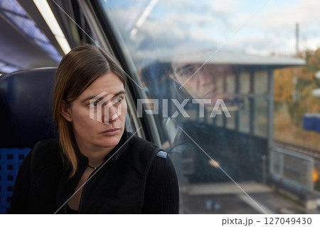 Woman on a train staring out he window 127049430
