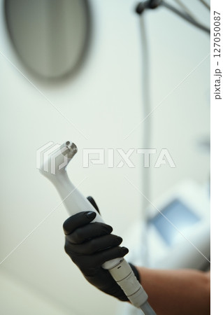 Hand holding a dental tool in a modern clinic Hand holding a dental tool in a modern clinic 127050087