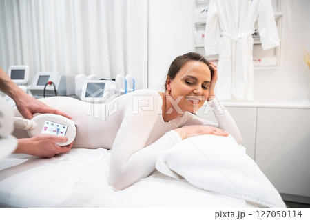 Woman enjoying a body treatment session in a wellness center Woman enjoying a body treatment session in a wellness center 127050114