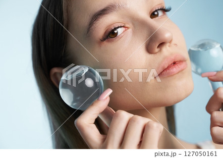 Young woman practicing facial therapy with cooling tools at home Young woman practicing facial therapy with cooling tools at home 127050161