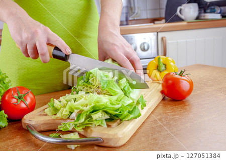 Woman chopping lettuce on cutting board... 127051384