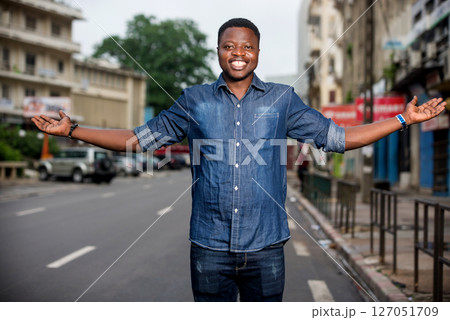 young happy man making welcome gesture on the street 127051709