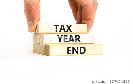 Tax year end symbol. Concept words Tax year end on beautiful wooden blocks. Beautiful white table white background. Businessman hand. Business tax year end concept. Copy space. 127051897