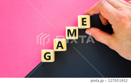 Game symbol. Concept word Game on beautiful wooden blocks. Businessman hand. Beautiful black and purple background. Business, lifestyle and game concept. Copy space. 127051952