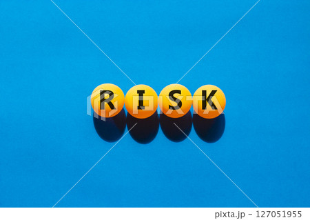 Risk symbol. Concept word Risk on beautiful yellow ping pong balls. Beautiful blue table blue background. Business, lifestyle, support and risk concept. Copy space. Risk symbol. Concept word Risk on beautiful yellow ping pong balls. Beautiful blue table blue background. Business, lifestyle, support and risk concept. Copy space. 127051955