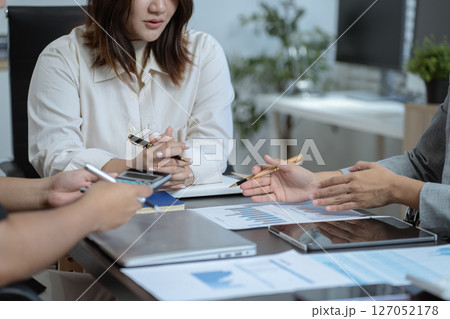 Business team doing paperwork, sitting at cafe on conference. Focused business team learning financial graphs, working on corporate project at briefing meeting. Business team doing paperwork, sitting at cafe on conference. Focused business team learning financial graphs, working on corporate project at briefing meeting. 127052178