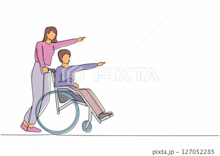 Single one line drawing couple of happy people while pointing in one direction. Caregiver woman pushing man on wheelchair, enjoy health care activity. Continuous line draw design vector illustration 127052285