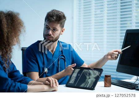 Knee model showing the process of osteoarthritis and knee arthroplasty, doctors explaining symptoms and treatment to patients. Knee model showing the process of osteoarthritis and knee arthroplasty, doctors explaining symptoms and treatment to patients. 127052578