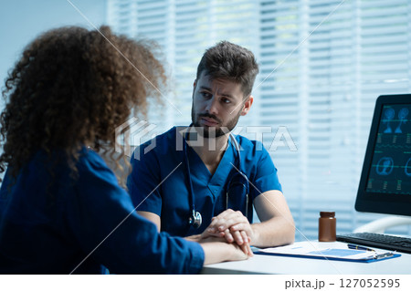 doctor talking with woman patient for monitoring and check up after surgery. doctor touching patient hand and consoling. 127052595